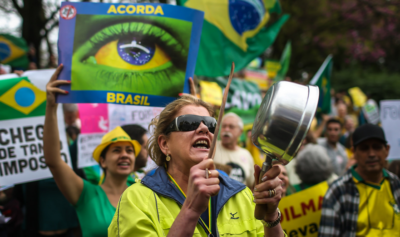 Mulher bate panela durante protesto (Foto: Jefferson Bernardes/AFP)