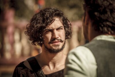 Miguel (Gabriel Leone) vem conversando até a frente da cooperativa
(Foto: Globo/Artur Meninea)