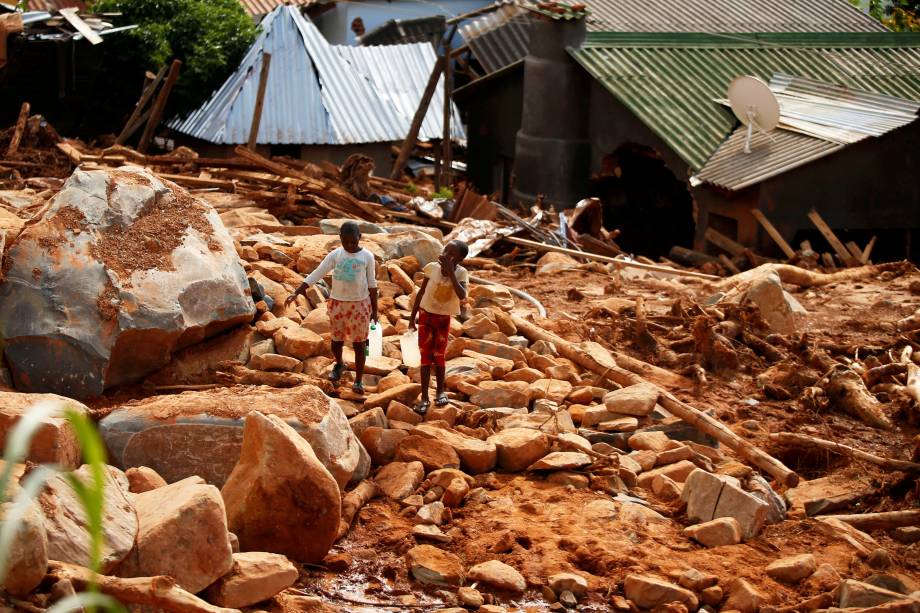 Crianças carregam galões de água entre escombros, após a passagem do ciclone Idai, na região de Chimanimani, fronteira entre o Moçambique e o Zimbábue (Philimon Bulawayo/Reuters)