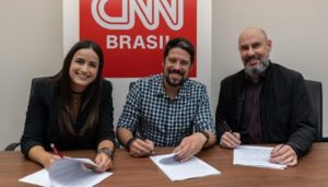 Mari Palma e Phelipe Siani assinam contrato com a CNN Brasil ao lado de Douglas Tavolaro, CEO do canal (Foto: Divulgação/CNN Brasil)