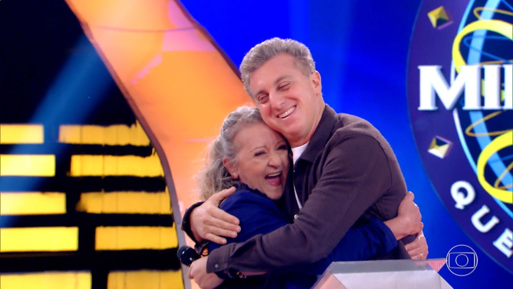 Luciano Huck ao lado de uma participante de seu programa na Globo (Foto: Reprodução)