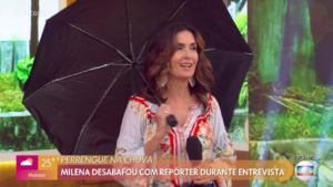 Fátima Bernardes precisou de guarda-chuva para recriar cena (Reprodução/Globoplay)