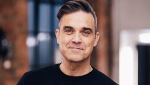 Mulher mostra foto de Robbie Williams nu na frente da TV (Foto: Reprodução)