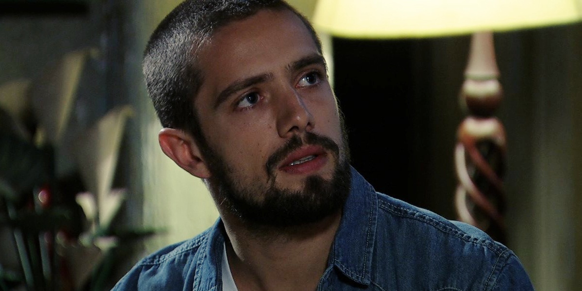 Vicente em cena da novela Império, cabelo raspado, com barba e jaqueta jeans