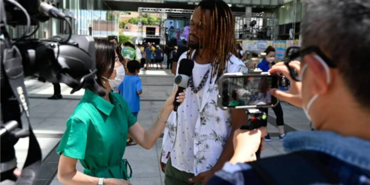 Toni Garrido sendo entrevistado pela repórter da Record no Brazilian Day - Foto: Reprodução