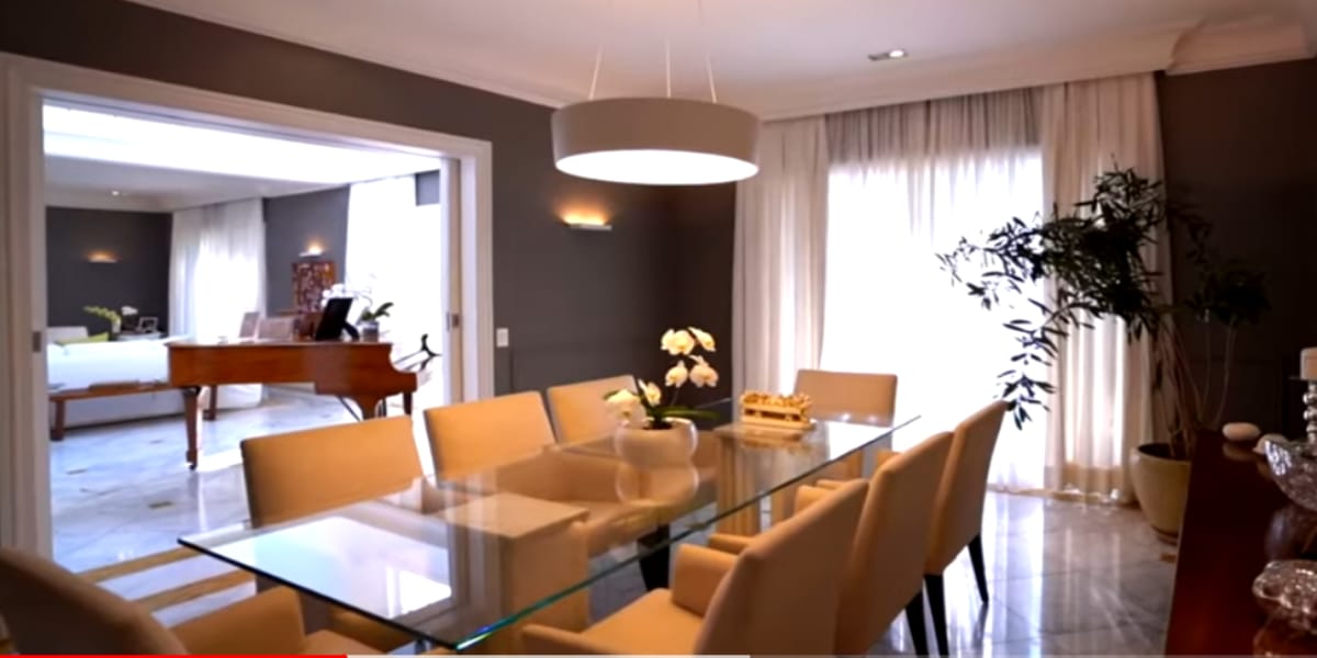 Sala de jantar com uma bela mesa de vidro (Reprodução: Youtube)