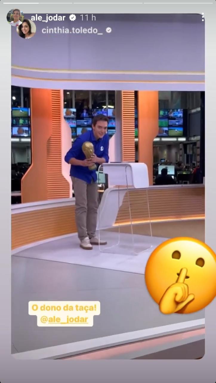 Alessandro Jodar mostrando a taça guardada atrás da bancada do Hora 1 (Imagem: Reprodução)