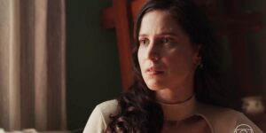 Regina usando blusa branca e cabelos longos pretos na novela Cara e Coragem