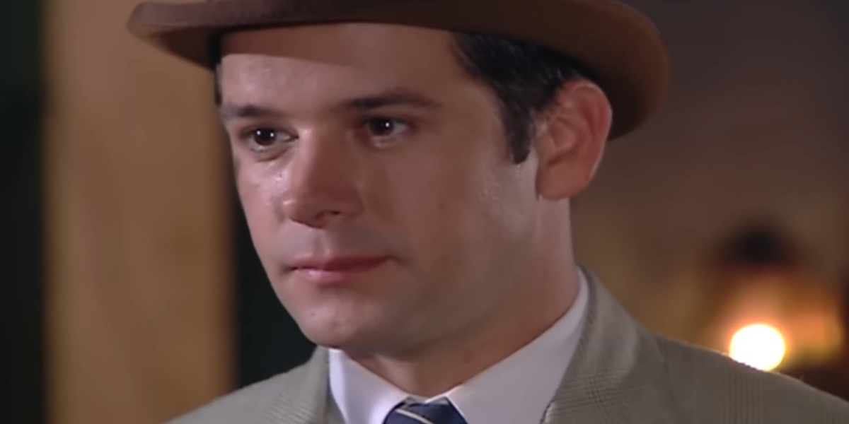 Danilo de chapeu, terno cinza e camisa branca na novela Chocolate com Pimenta