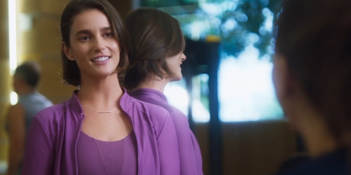 Helena usa roupa esportiva na cor lilás e está sorridente na novela Vai na Fé