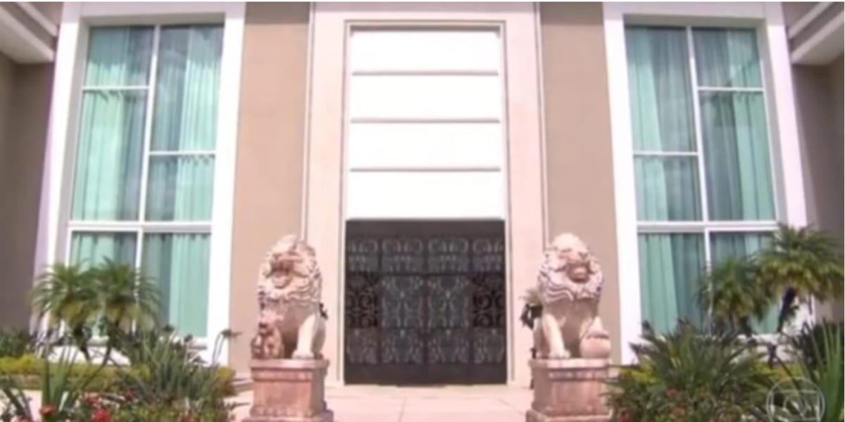 Porta de entrada da mansão com estátuas de leões (Reprodução: Youtube)