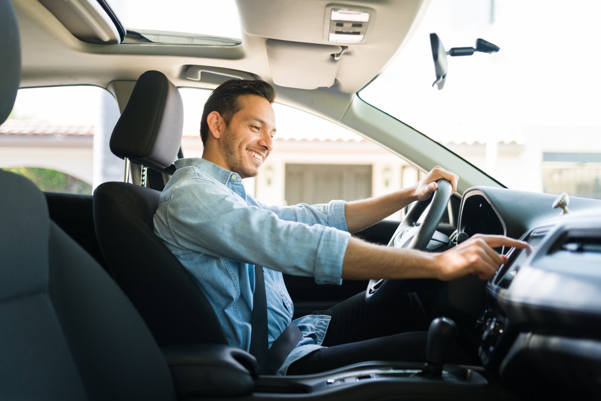 Motorista mexendo no carro (Reprodução - Shutterstock)