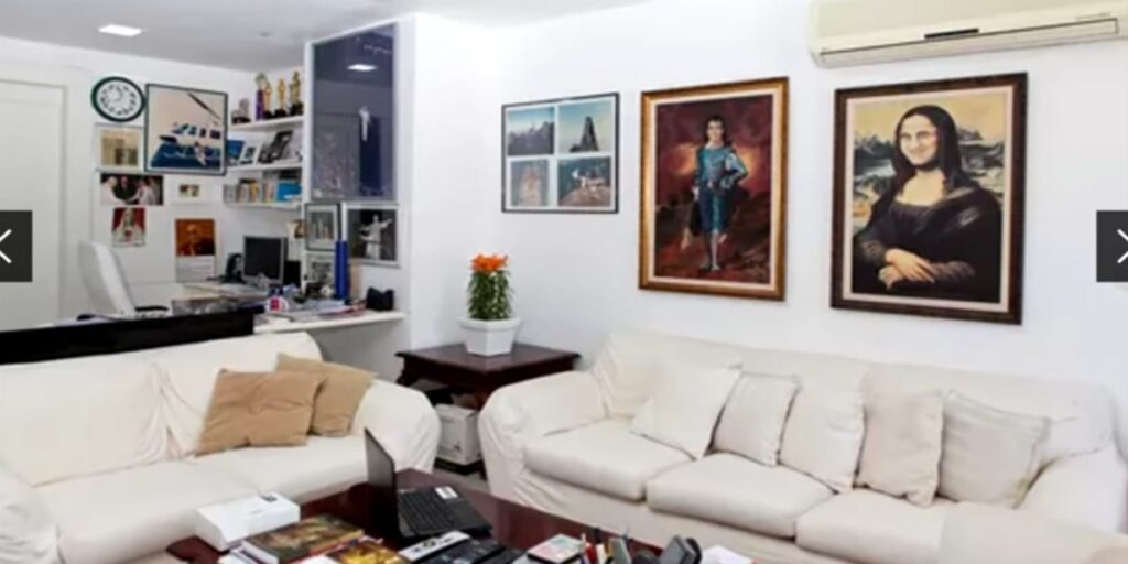 A sala de estar recheada de quadros de artes e sofás confortáveis (Reprodução: Youtube)