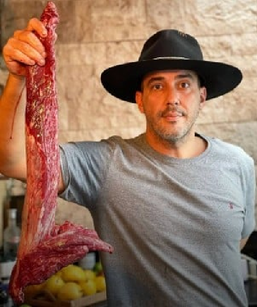 André Marques com um pedaço de carne em sua loja de carnes (Foto: Reprodução/ Internet)