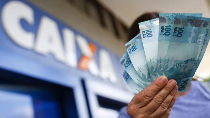 A woman leaving the Caixa Economica Federal carrying cash (Photo: Reproduction/Internet)