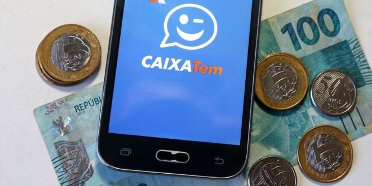 Celular com Caixa Tem e dinheiro na mesa - Foto Reprodução Internet