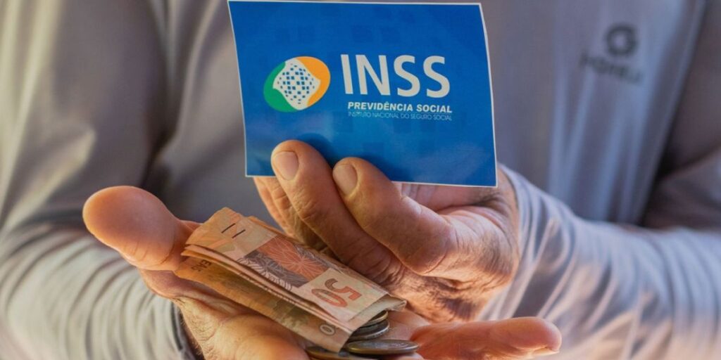 Beneficiário do INSS segurando cartão e notas de dinheiro (Foto: Reprodução / Internet)