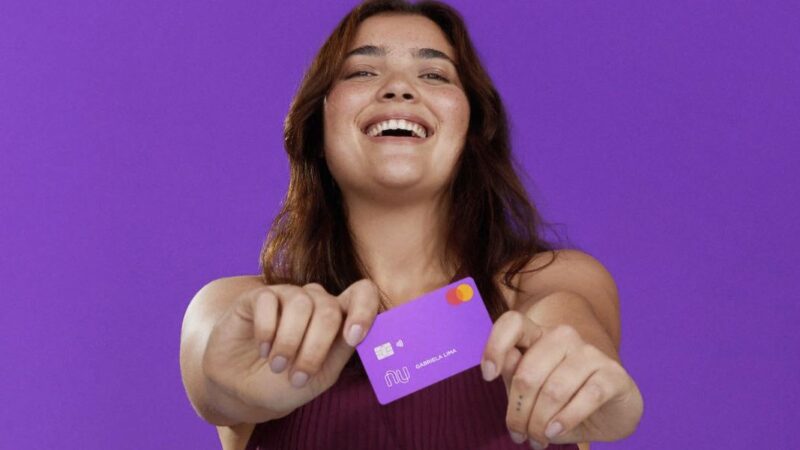 Pessoa feliz segurando cartão do Nubank (Foto: Reprodução / site do banco)