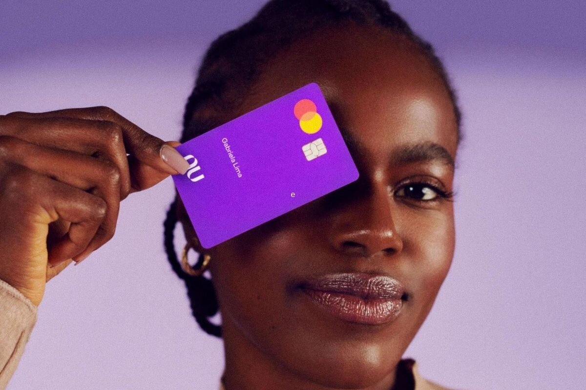 Mulher segurando o Cartão Nubank (Foto: Reprodução, Site do banco)