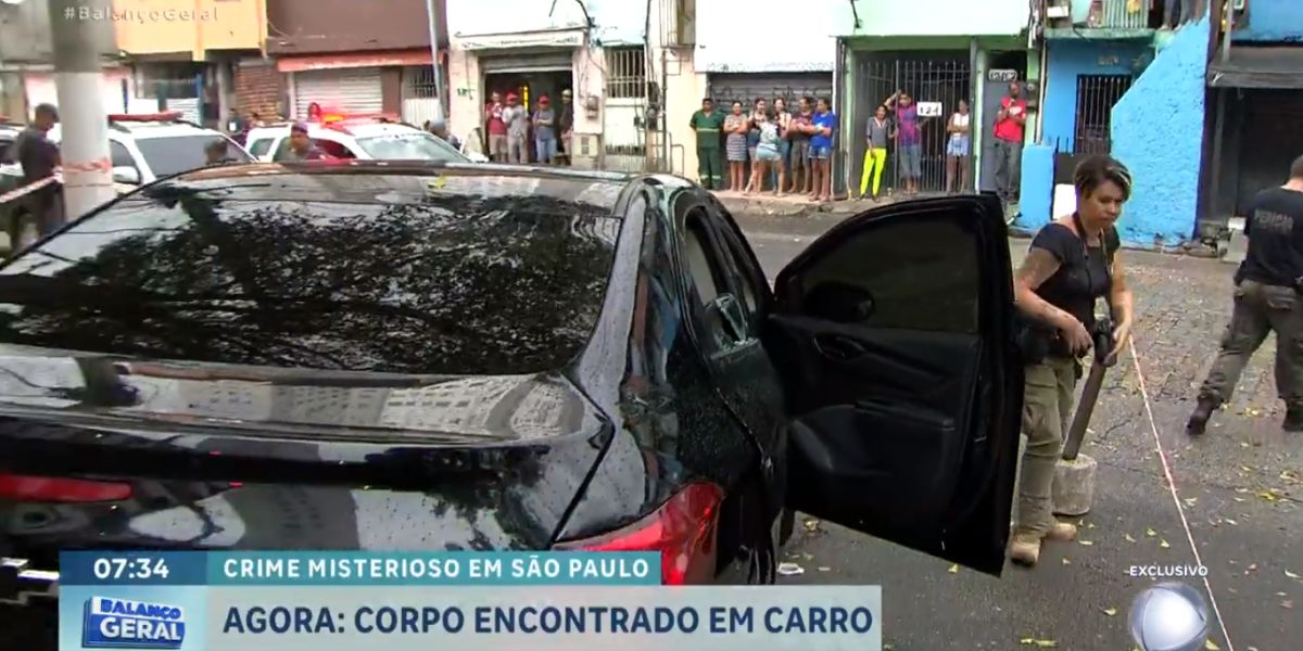 O corpo ainda estava dentro do carro quando a reportagem chegou (Reprodução: Record)