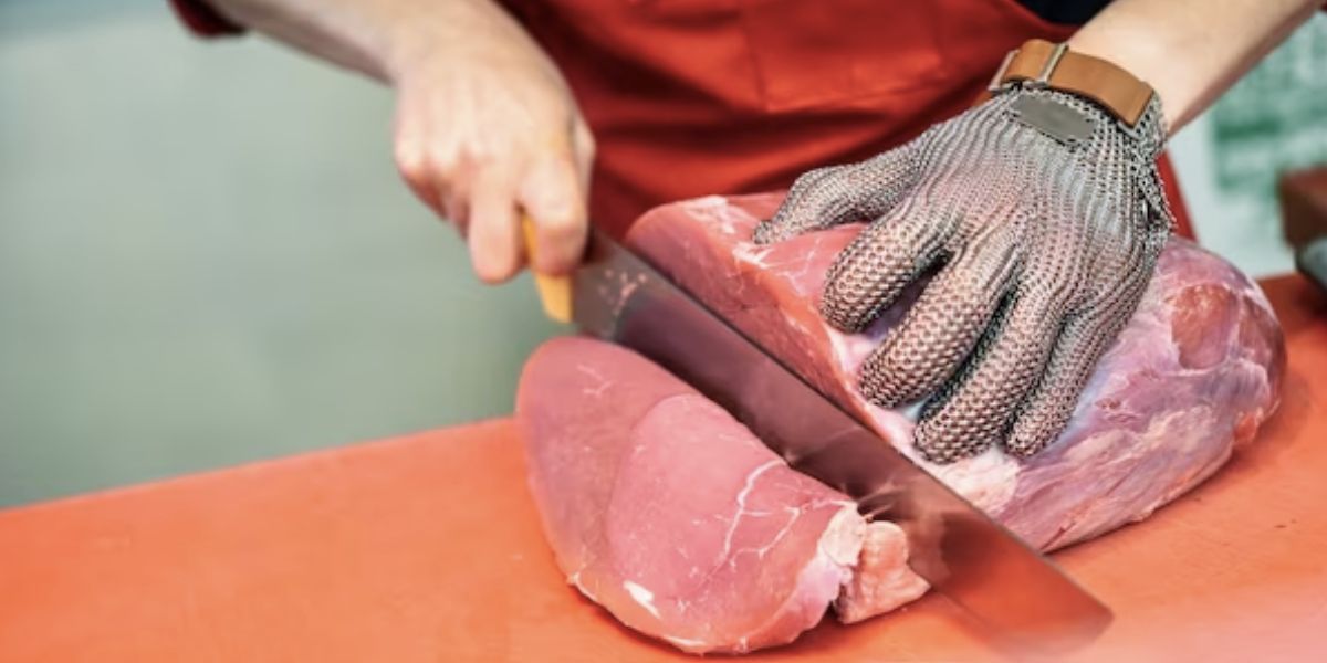 Homem cortando carne em açougue (Foto: Reprodução / Freepik)