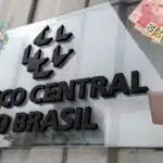 Logo do Banco Central e pessoas com dinheiro - Foto Reprodução Internet