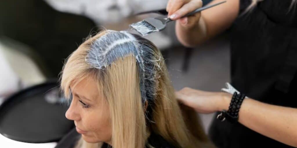 Mulher pintando cabelo (Foto: Reprodução / Freepik)