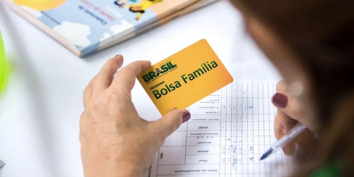 Mulher segurando cartão do Bolsa Família (Foto: Reprodução / Ascom / PMA)