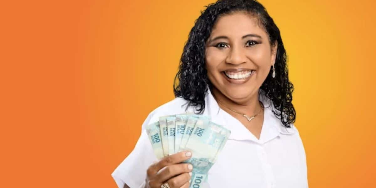 Mulher segurando notas de cem reais (Foto: Reprodução / Freepik)