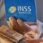 Beneficiário segurando cartão do INSS e dinheiro (Foto: Reprodução / Internet)