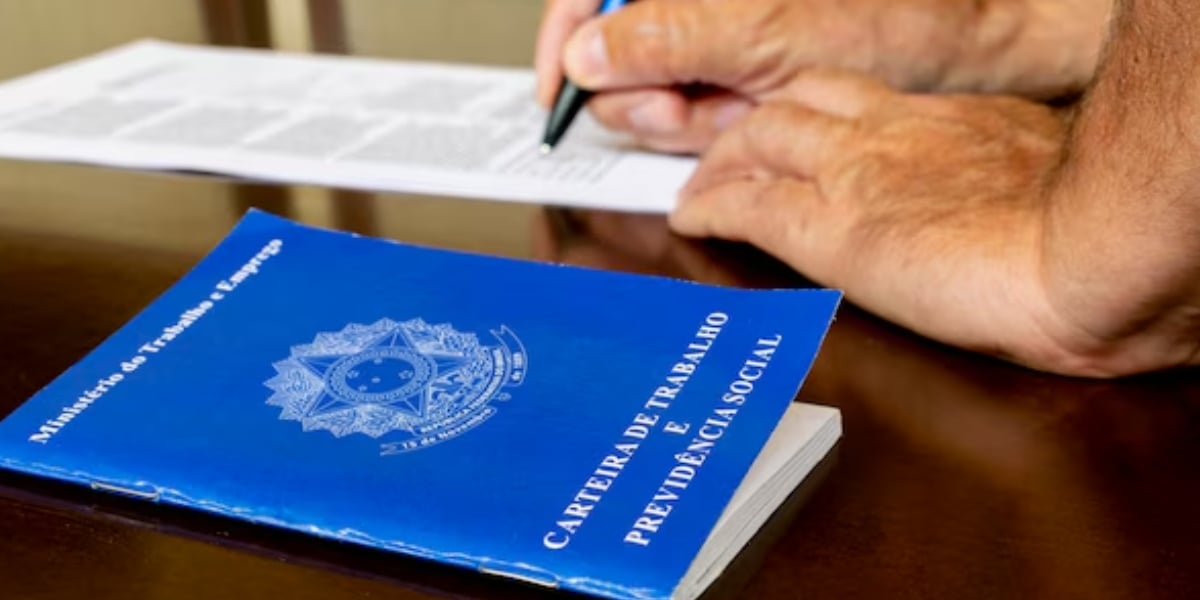 Carteira de trabalho e homem assinando documento (Foto: Reprodução / Freepik)