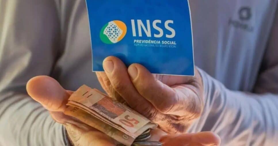 Idoso segurando notas de cem reais e cartão do INSS (Foto: Reprodução / Internet)